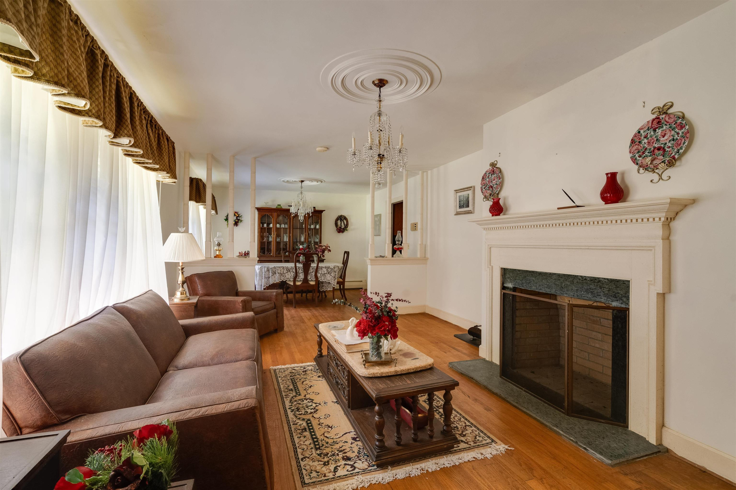 7676 Webbs Mill Road Spring Hope, NC 27882 - Photo 7 of 10 a living room with furniture a fireplace and a chandelier