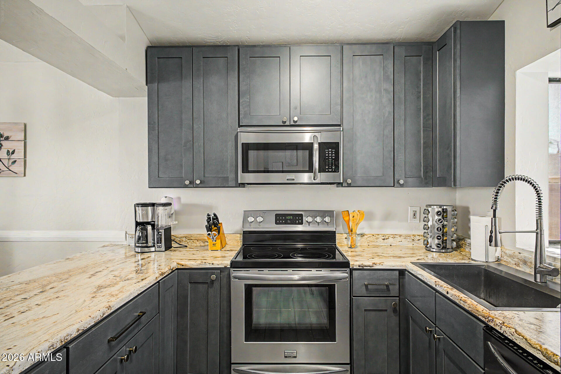 4725 East Brown Road, Unit 70 Mesa, AZ 85205 - Photo 11 of 25 a kitchen with stainless steel appliances granite countertop a sink stove and microwave