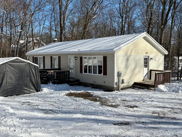 a view of a house with a yard covered in snow