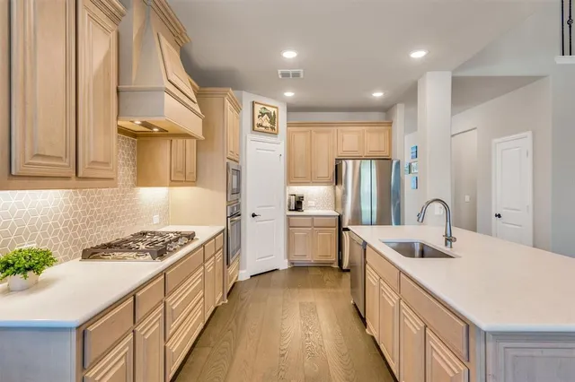 a kitchen with stainless steel appliances granite countertop a sink stove and refrigerator
