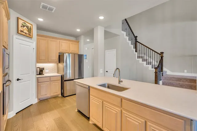 a kitchen with a refrigerator sink and cabinets