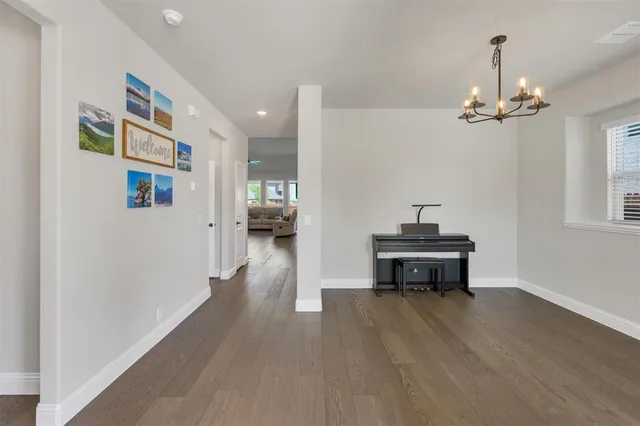 a view of a livingroom with furniture a chandelier and wooden floor