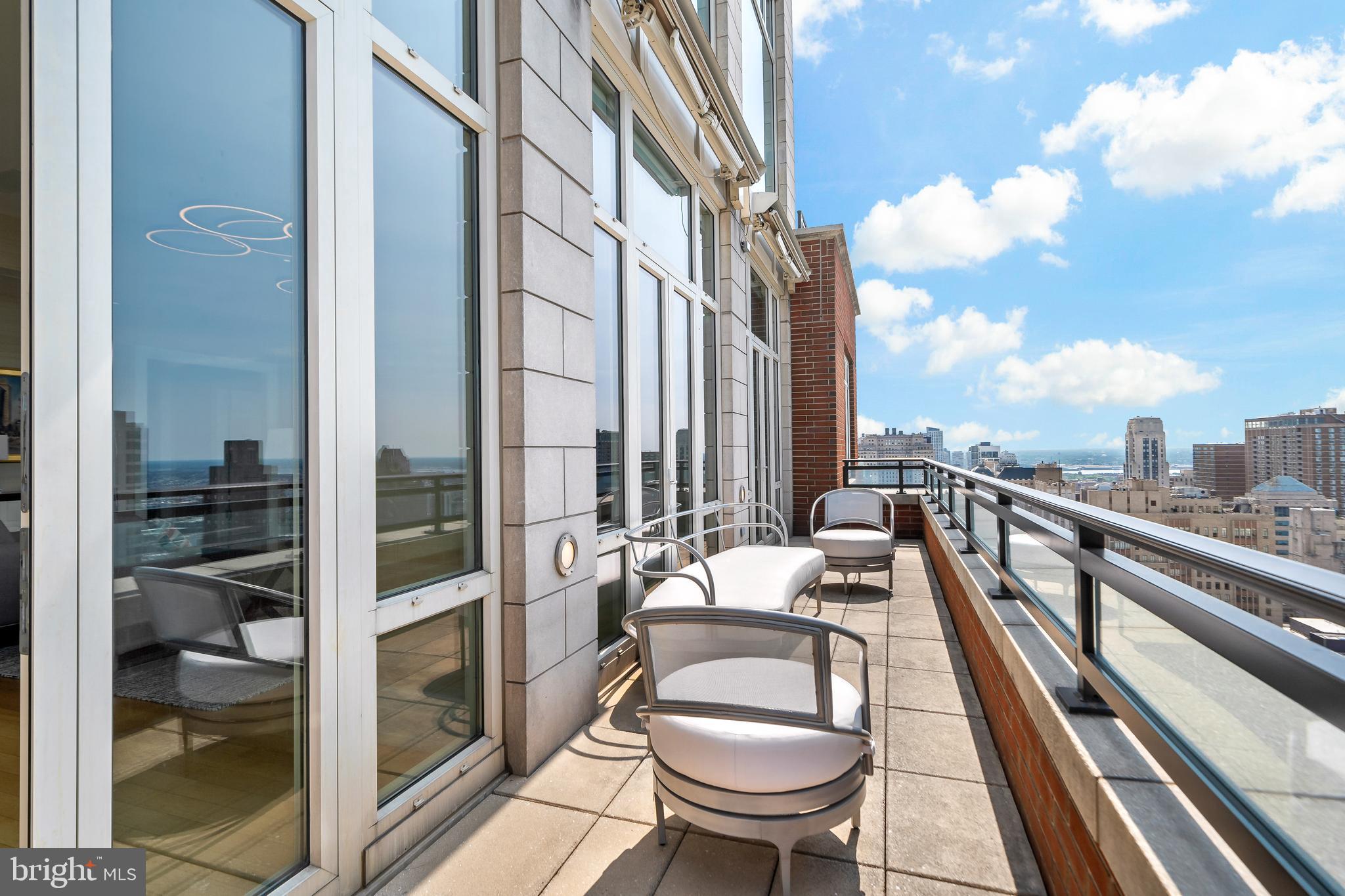 130 South 18th Street, Unit 3102 Philadelphia, PA 19103 - Photo 4 of 6 a balcony with wooden benches and a couch