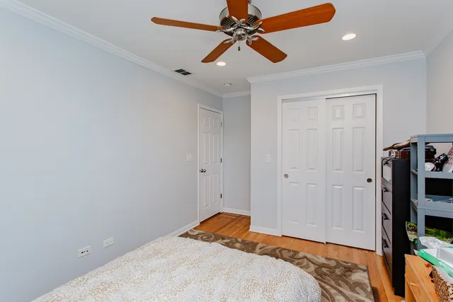 a bedroom with a bed and a flat tv screen on a dresser
