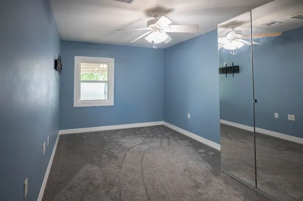 a view of a house with a big yard and large trees