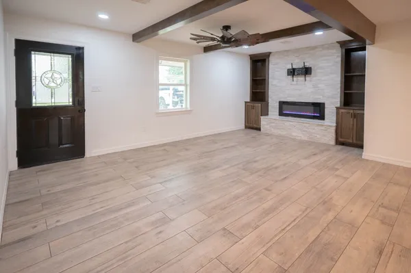 an empty room with windows and cabinet