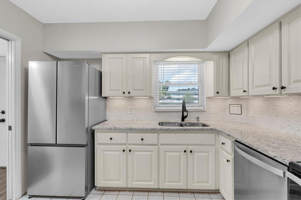 2417 Persian Drive, Unit 23 Clearwater, FL 33763 - Photo 14 of 48 a kitchen with a refrigerator sink and cabinets