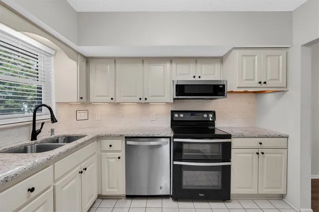 a kitchen with white cabinets and stainless steel appliances