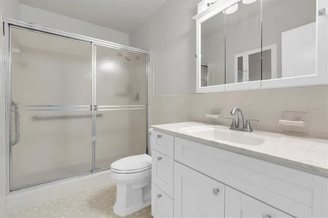 a bathroom with a granite countertop sink toilet and shower