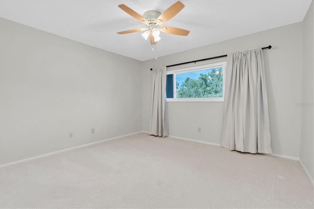 2417 Persian Drive, Unit 23 Clearwater, FL 33763 - Photo 23 of 48 an empty room with windows and fan