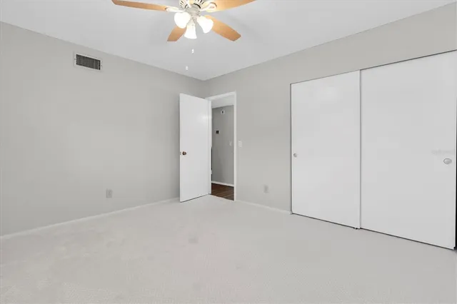 an empty room with a chandelier fan