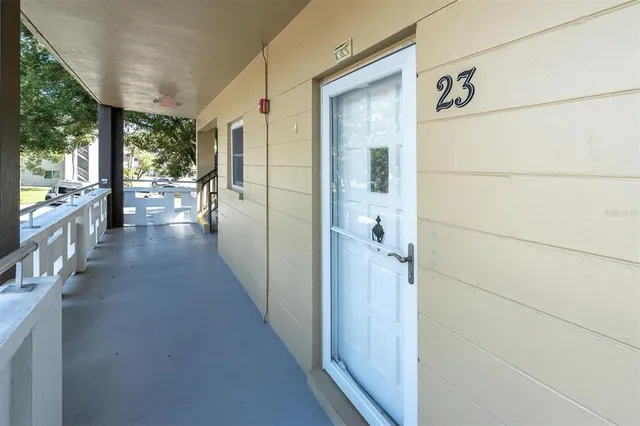 a view of a hallway with wooden floor and a room