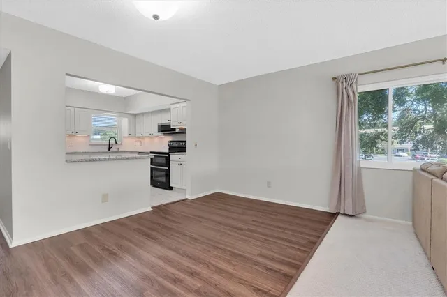 a kitchen with granite countertop a refrigerator and wooden floor