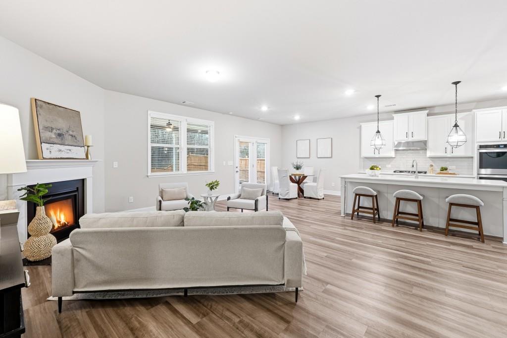 1849 Hanwoo Lane Powder Springs, GA 30127 - Photo 16 of 47 a living room with stainless steel appliances kitchen island granite countertop furniture a fireplace and a wooden floor