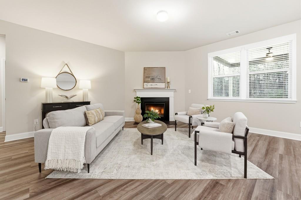 1849 Hanwoo Lane Powder Springs, GA 30127 - Photo 17 of 47 a living room with furniture a fireplace and wooden floor
