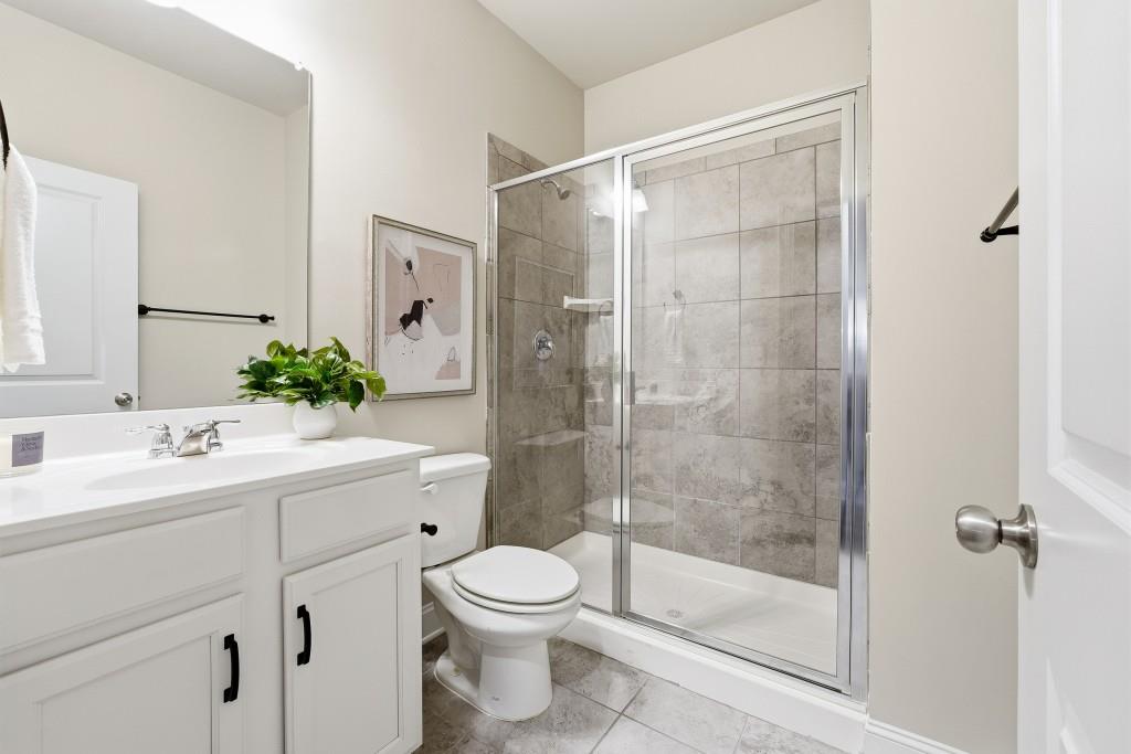 1849 Hanwoo Lane Powder Springs, GA 30127 - Photo 20 of 47 a bathroom with a shower sink vanity mirror and toilet