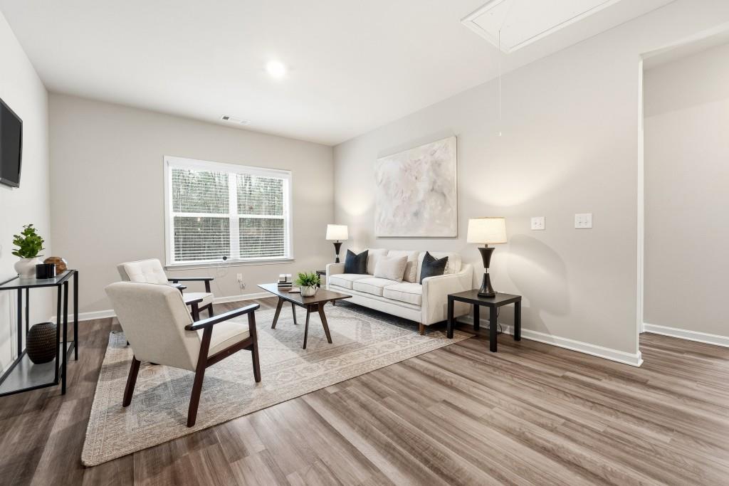 1849 Hanwoo Lane Powder Springs, GA 30127 - Photo 23 of 47 a living room with furniture and a wooden floor