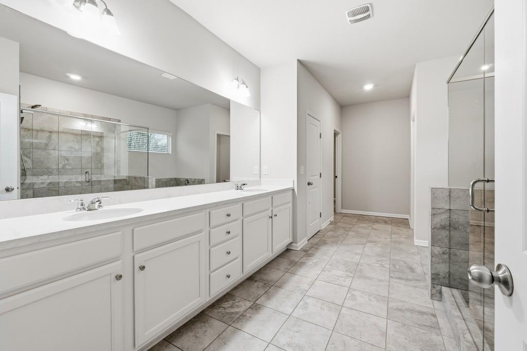1849 Hanwoo Lane Powder Springs, GA 30127 - Photo 27 of 47 a spacious bathroom with a double vanity sink shower and mirror