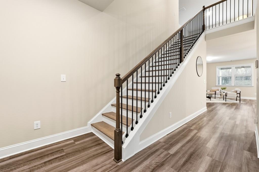 1849 Hanwoo Lane Powder Springs, GA 30127 - Photo 7 of 47 a view of a hallway with wooden floor and staircase