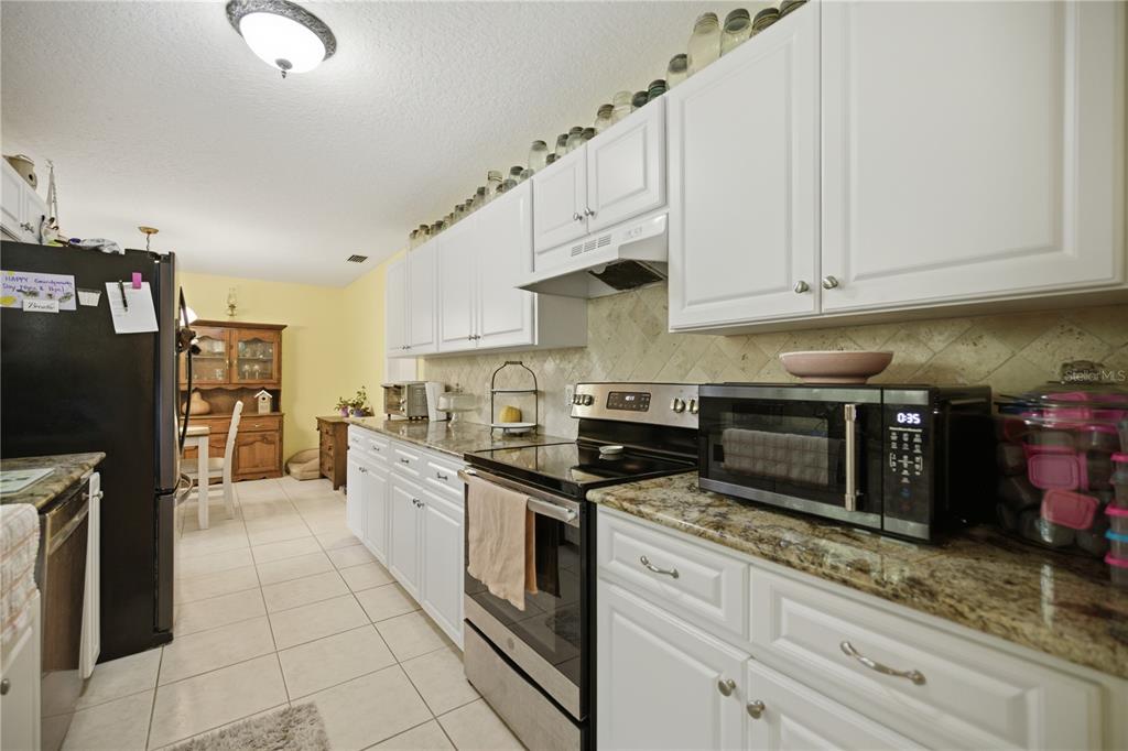 17900 Northwest 120th Avenue Road Reddick, FL 32686 - Photo 40 of 45 a kitchen with stainless steel appliances granite countertop a refrigerator sink and stove