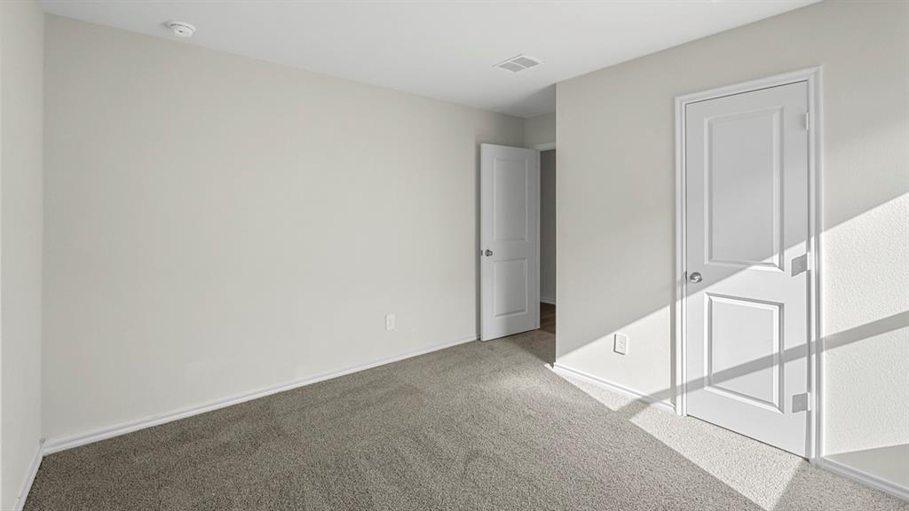 1953 Freeman Street Tyler, TX 75704 - Photo 25 of 32 Carpeted interior room featuring light gray walls, white trim, and a white paneled door