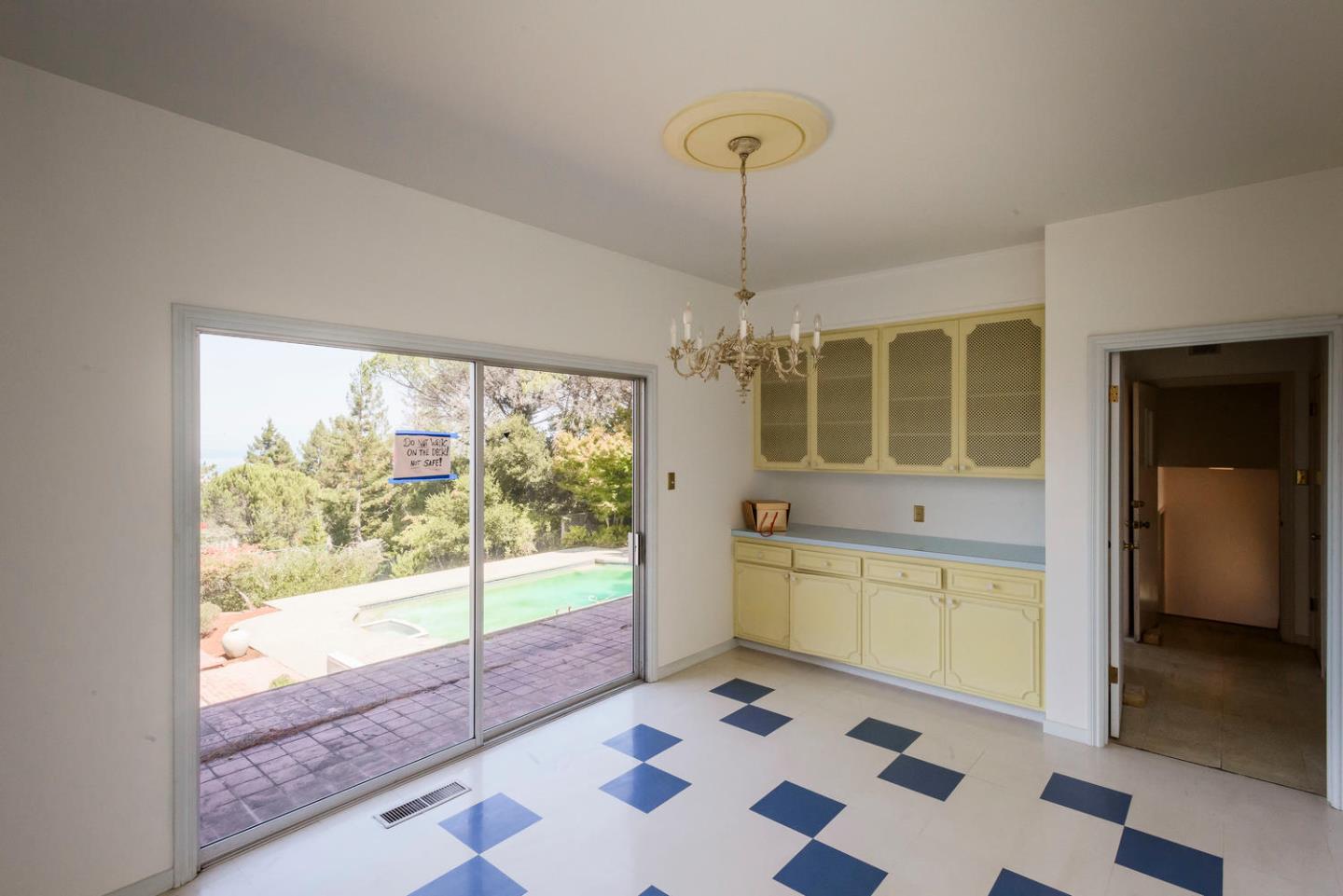 460 Pullman Road Hillsborough, CA 94010 - Photo 15 of 34 a room with a black white checkered floor with a dining table and chairs