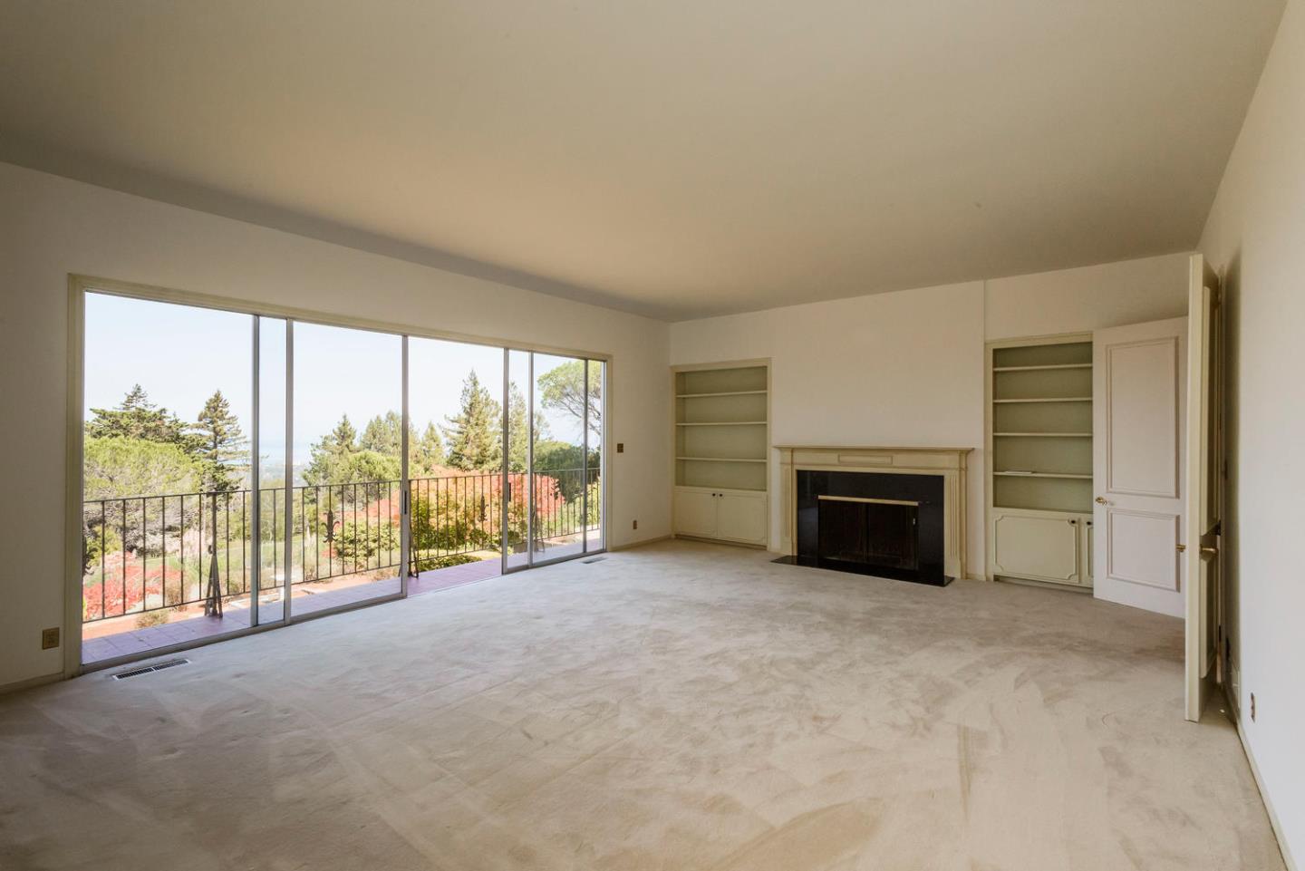 460 Pullman Road Hillsborough, CA 94010 - Photo 8 of 34 a view of an empty room with a fireplace and a window