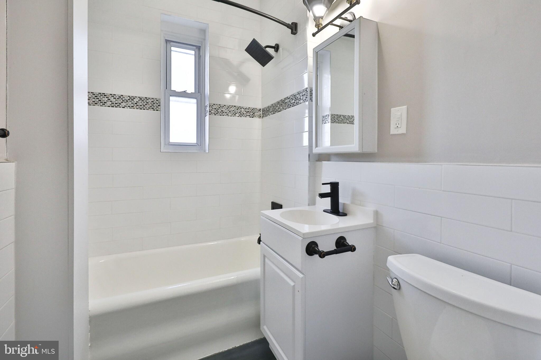 4247 Locust Street, Unit 1B413 Philadelphia, PA 19104 - Photo 32 of 38 a bathroom with a sink a toilet and shower
