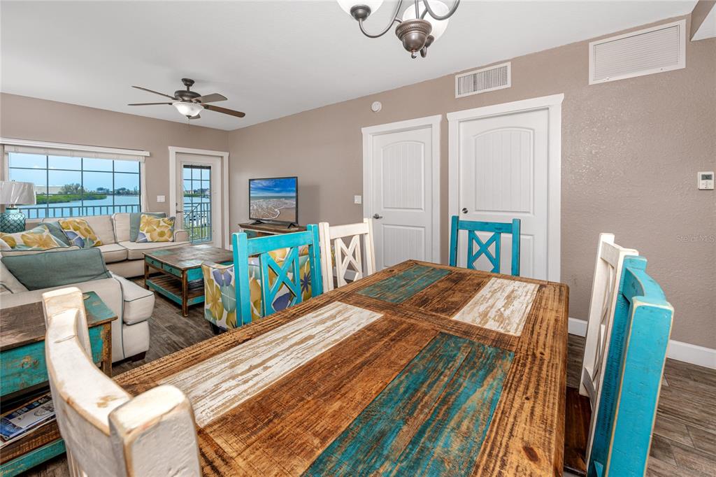 399 2nd Street, Unit 217 Indian Rocks Beach, FL 33785 - Photo 11 of 44 a view of a dining room with furniture a chandelier and wooden floor