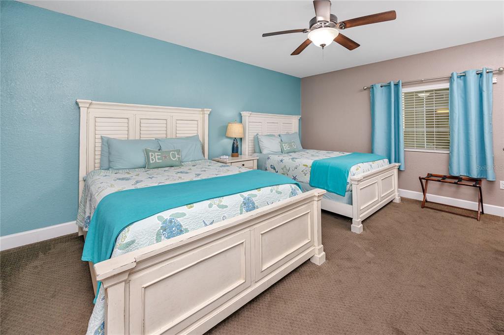 399 2nd Street, Unit 217 Indian Rocks Beach, FL 33785 - Photo 21 of 44 a bedroom with two beds and a chandelier