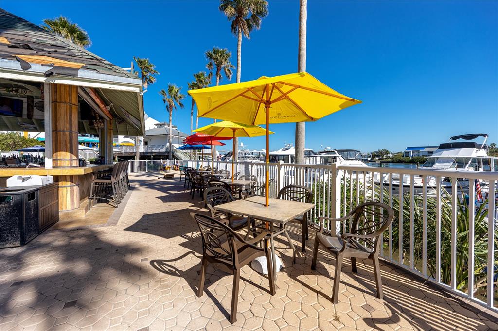 399 2nd Street, Unit 217 Indian Rocks Beach, FL 33785 - Photo 41 of 44 a view of a tables and chairs under an umbrella in patio