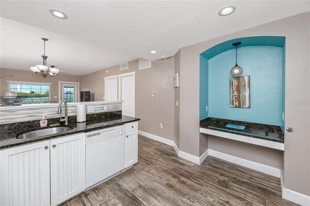 399 2nd Street, Unit 217 Indian Rocks Beach, FL 33785 - Photo 8 of 44 a hallway with granite countertop a sink and a stove top oven