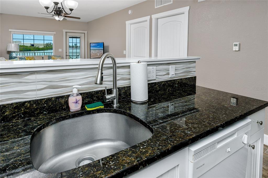 399 2nd Street, Unit 217 Indian Rocks Beach, FL 33785 - Photo 9 of 44 a kitchen with a granite countertop sink a stove and a granite counter top