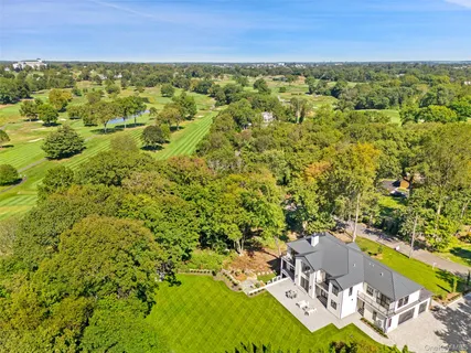 an aerial view of residential houses with outdoor space and trees