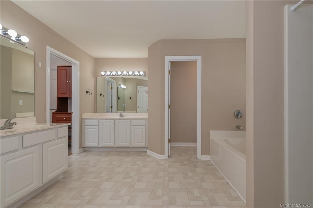 52 Wildbriar Road Fletcher, NC 28732 - Photo 25 of 29 a bathroom with a double vanity sink a toilet a mirror and shower
