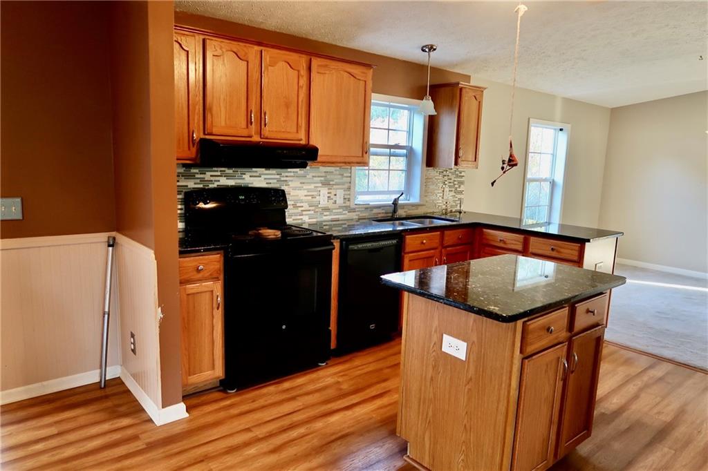 128 Airport Road Mercer, PA 16137 - Photo 11 of 36 a kitchen with stainless steel appliances granite countertop a stove a refrigerator a sink dishwasher and wooden cabinets with wooden floor