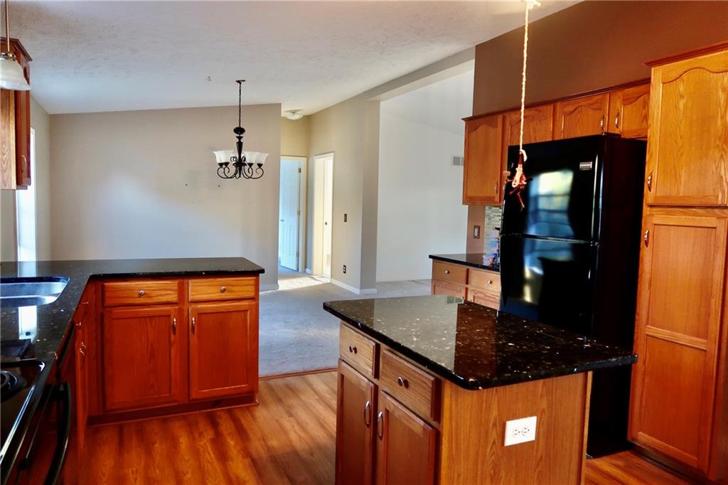 128 Airport Road Mercer, PA 16137 - Photo 19 of 36 a kitchen with stainless steel appliances granite countertop a refrigerator a stove and a wooden floors