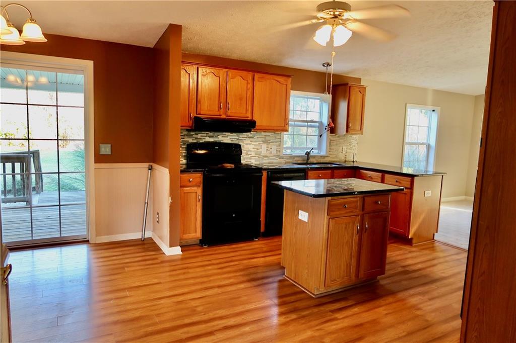 128 Airport Road Mercer, PA 16137 - Photo 9 of 36 a kitchen with kitchen island granite countertop wooden floors and a sink
