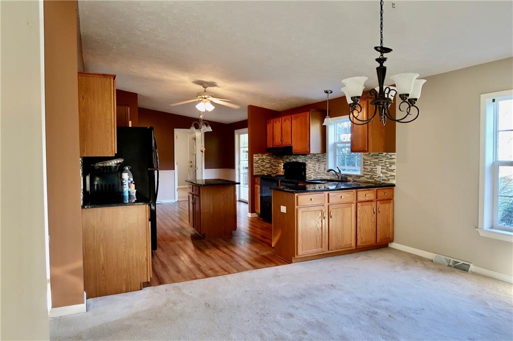 128 Airport Road Mercer, PA 16137 - Photo 10 of 36 a kitchen view with stainless steel appliances granite countertop a refrigerator a sink dishwasher a stove and a dining table with wooden floor