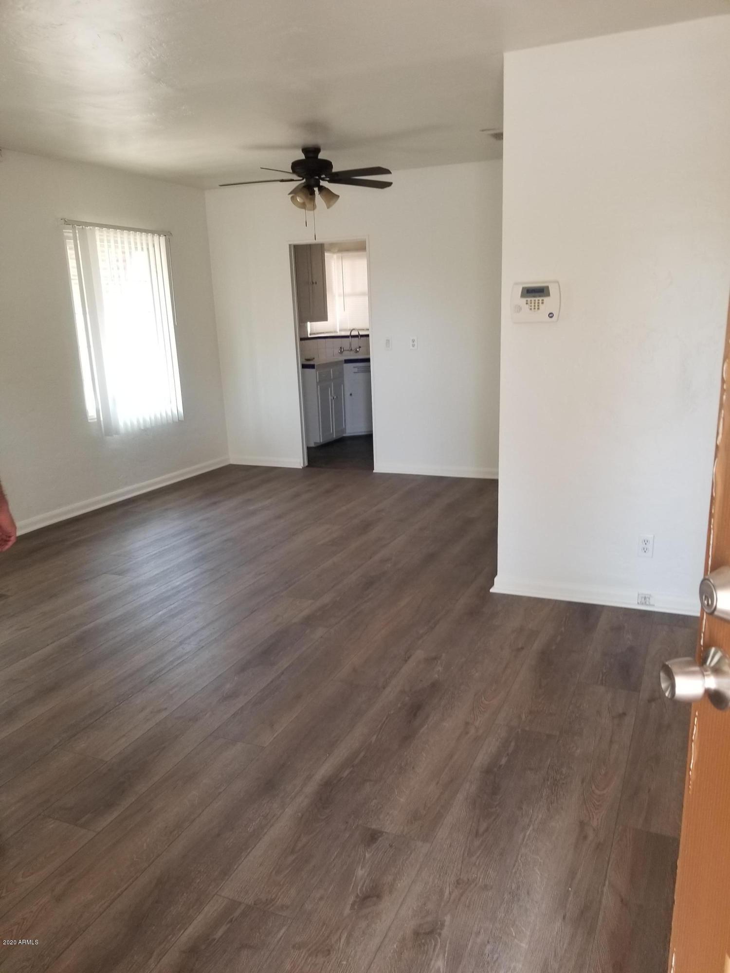 26 East Hatcher Road Phoenix, AZ 85020 - Photo 7 of 31 an empty room with wooden floor cabinet and windows