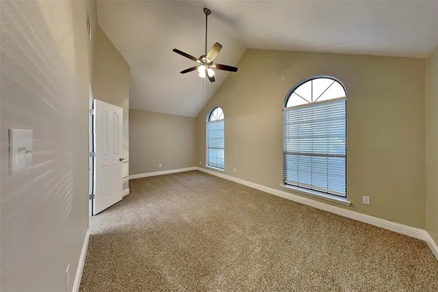an empty room with a windows and ceiling fan