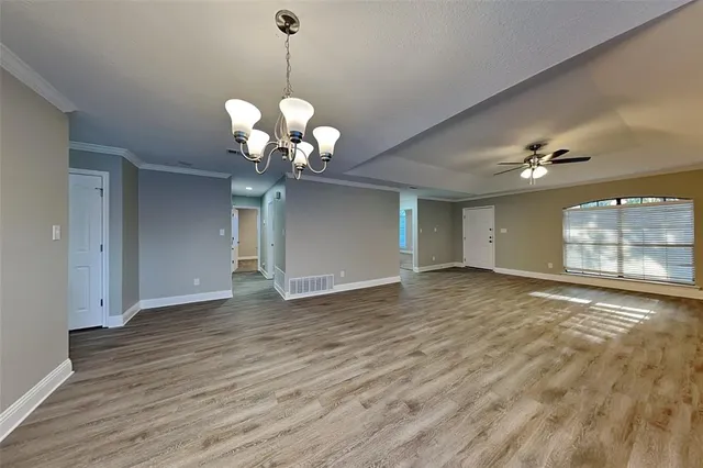 a view of a room with wooden floor and chandelier