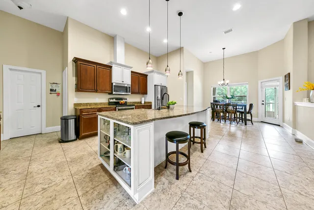 a kitchen with stainless steel appliances a stove a sink a oven a dining table and chairs