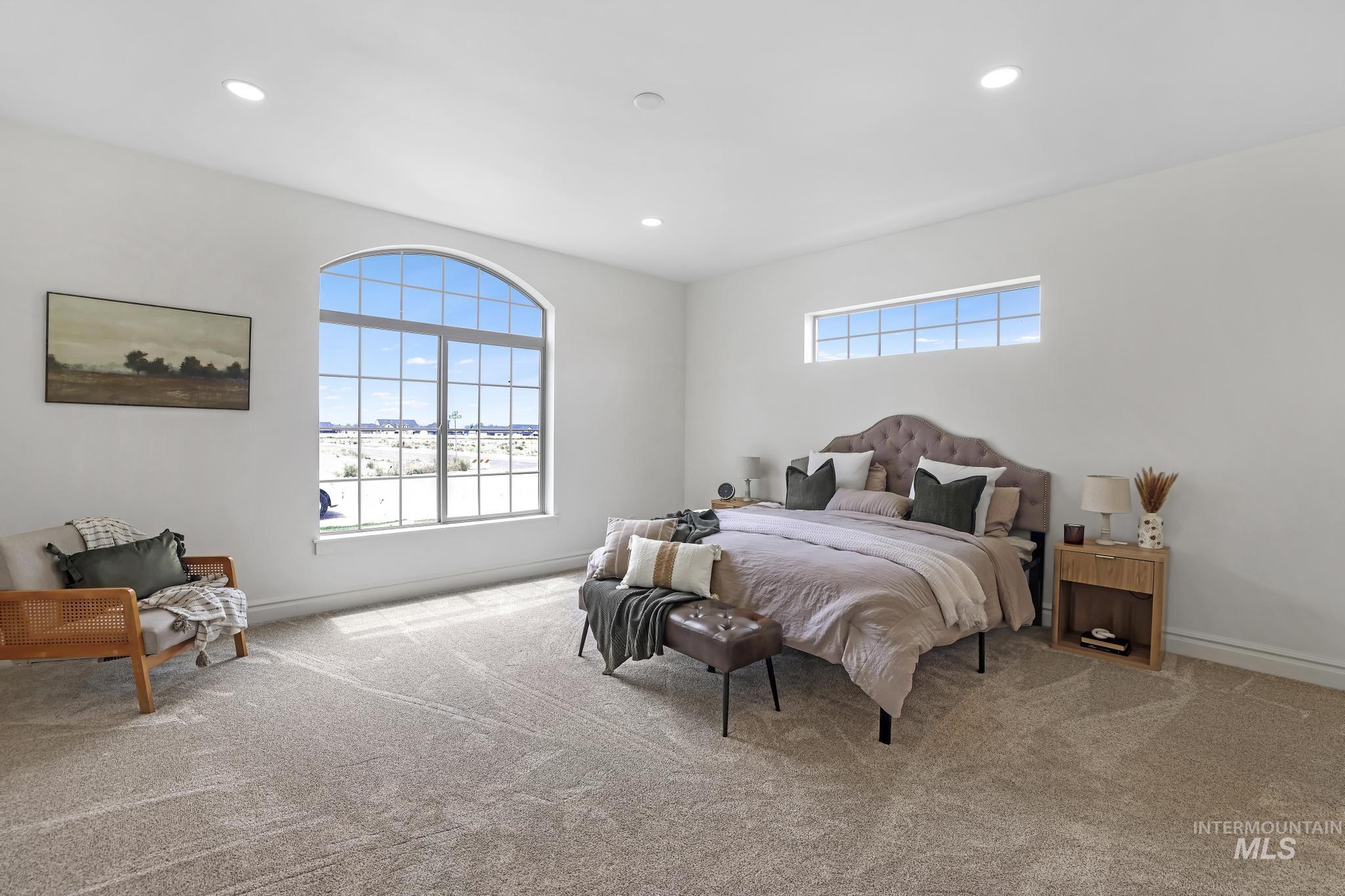 866 Quartz Road Kimberly, ID 83341 - Photo 20 of 48 Spacious room featuring a large arched window with grid patterns, an additional horizontal transom window, recessed ceiling lighting, and light-toned carpet flooring