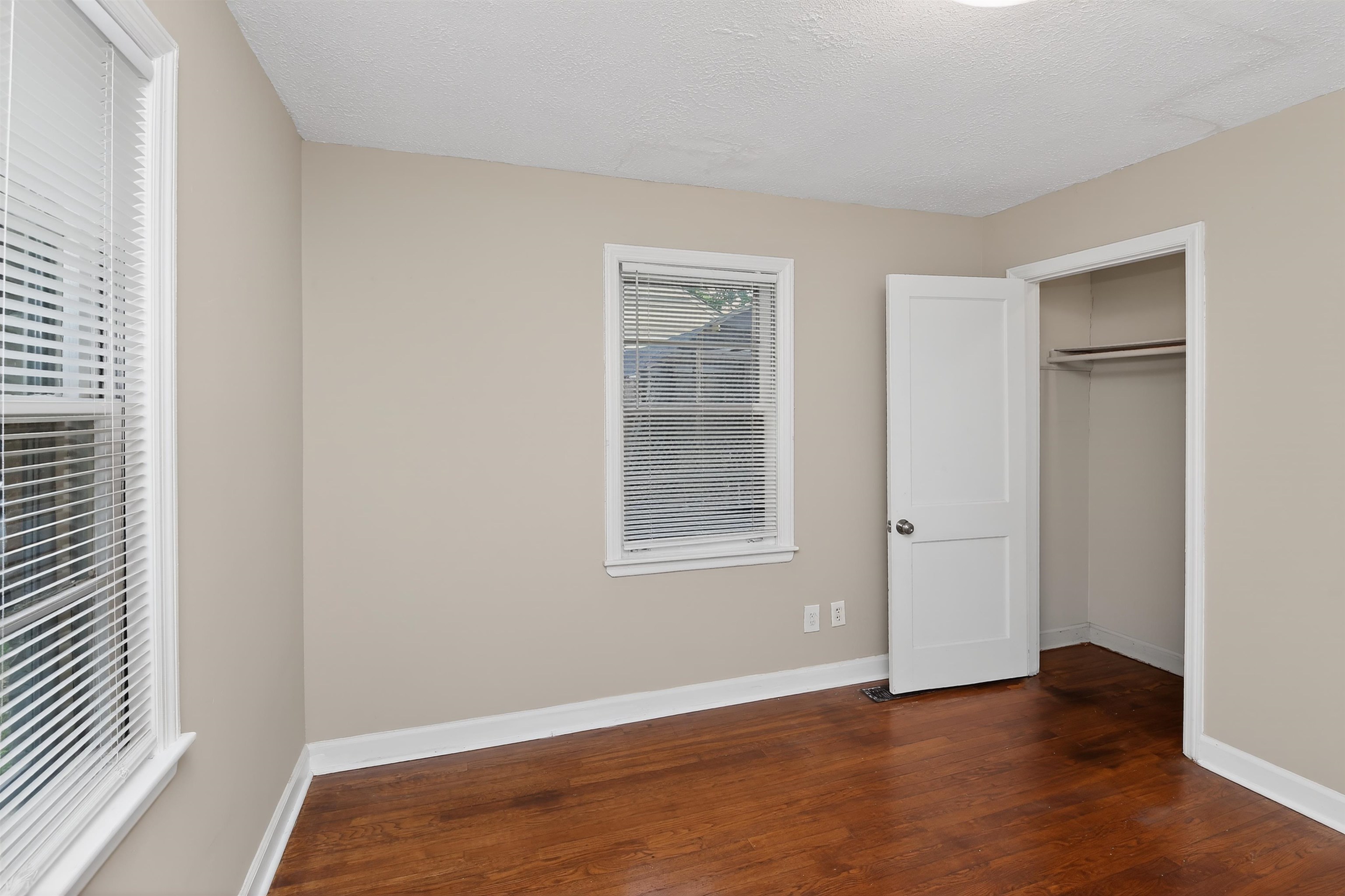 2840 Allen Road Memphis, TN 38128 - Photo 24 of 31 Wood-finish flooring throughout, featuring two windows with horizontal blinds, a ceiling-mounted light fixture, and a closet with a hanging rod