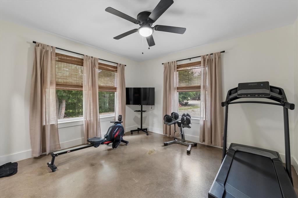 286 Benevolence Way China Spring, TX 76633 - Photo 18 of 37 Versatile bonus room featuring a ceiling fan with integrated lighting, polished concrete flooring, and multiple windows with woven wood blinds and drapery