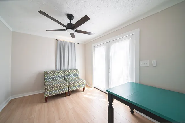 a view of workspace and bedroom with wooden floor