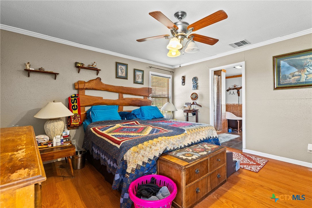 425 Old Pleasanton Road Poteet, TX 78065 - Photo 15 of 38 a bedroom with bed and wooden floor
