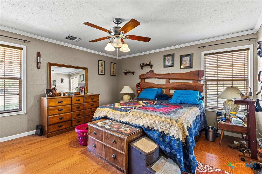 425 Old Pleasanton Road Poteet, TX 78065 - Photo 16 of 38 a bedroom with a bed and a chandelier