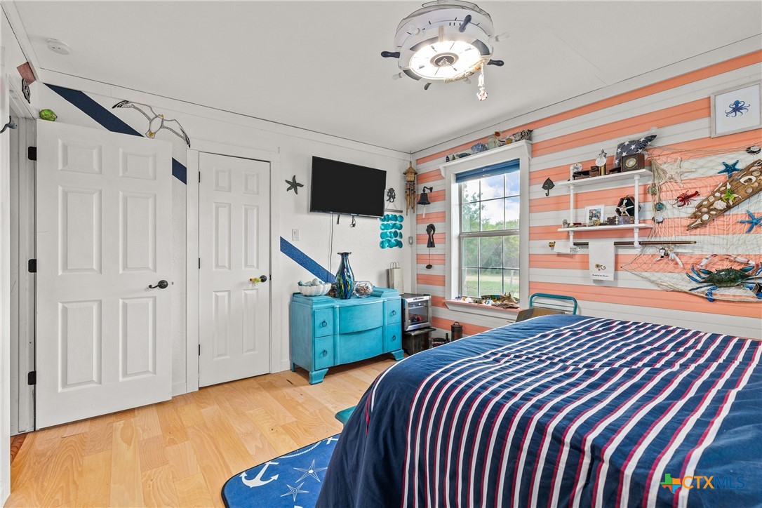 425 Old Pleasanton Road Poteet, TX 78065 - Photo 19 of 38 a bedroom with a large bed and a chandelier